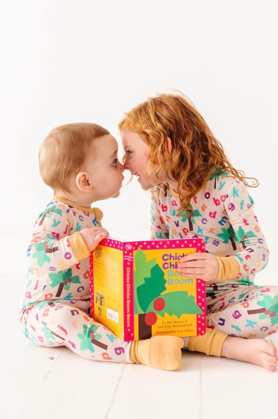 Kids reading Chicka Chicka Boom Boom in matching pajamas