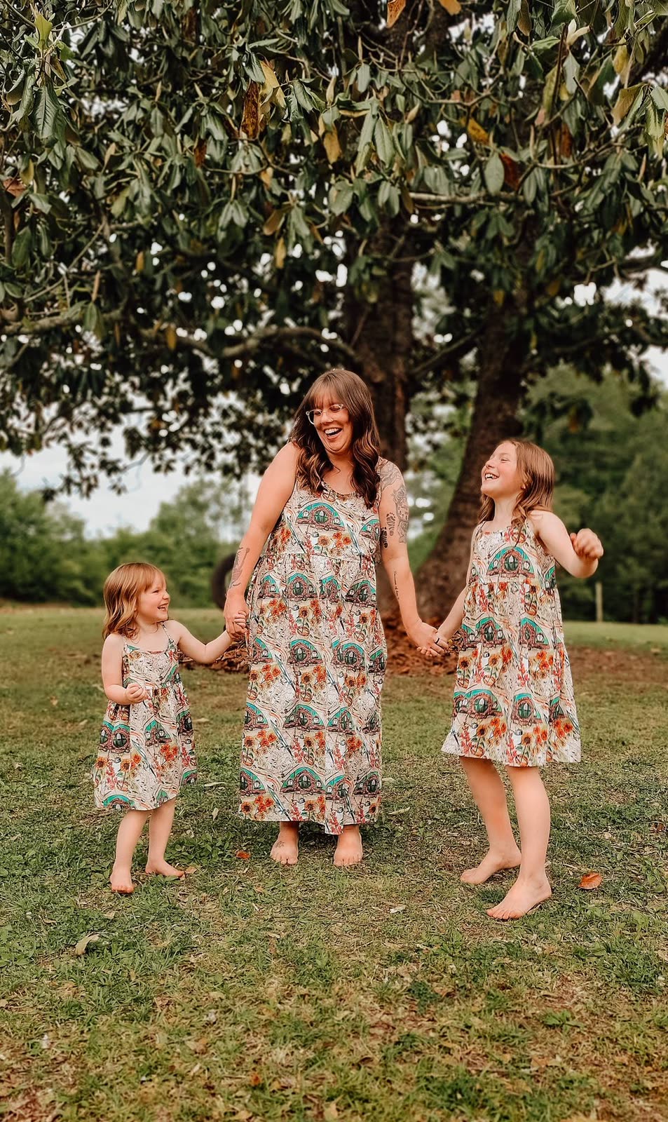 A mother and two girls laughing together in matching Shire dresses