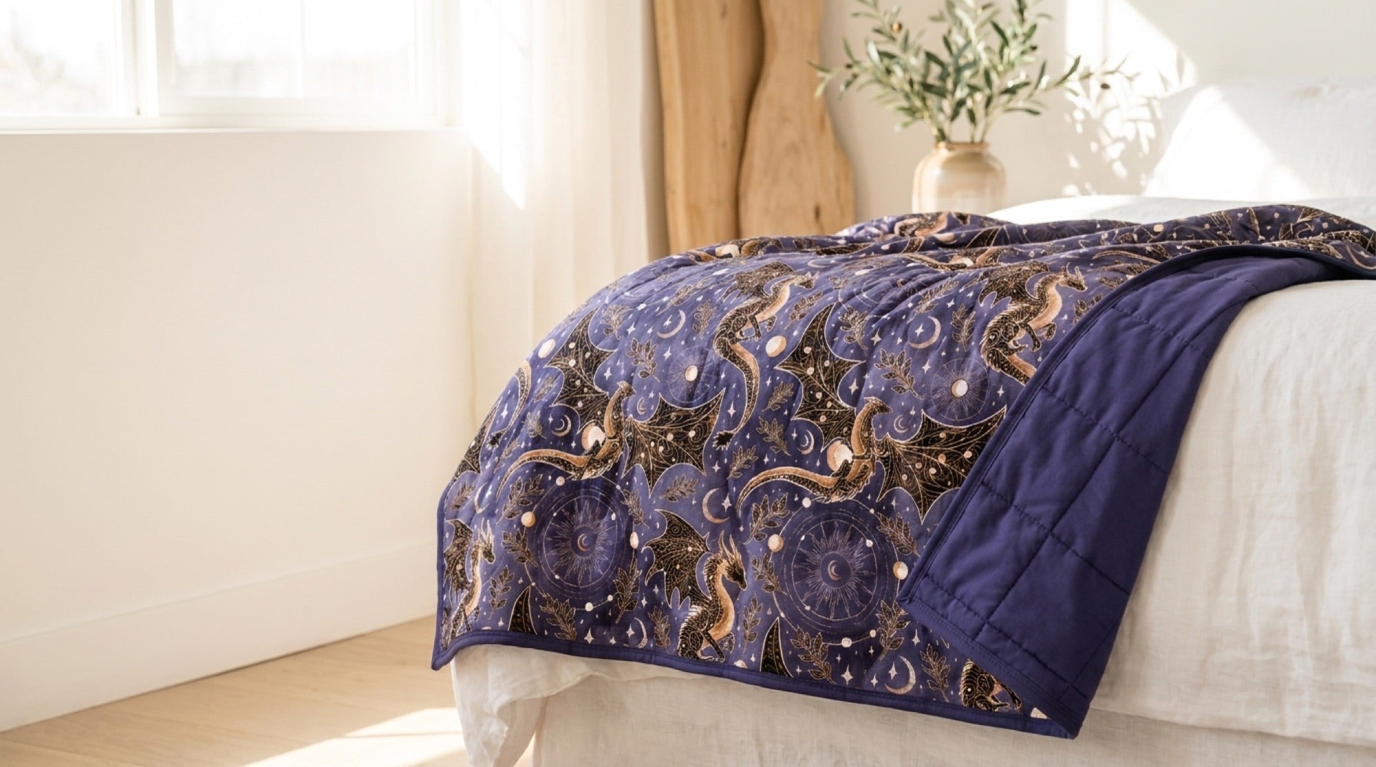 Violent Skies quilted oversized blanket draped over a bed in morning light